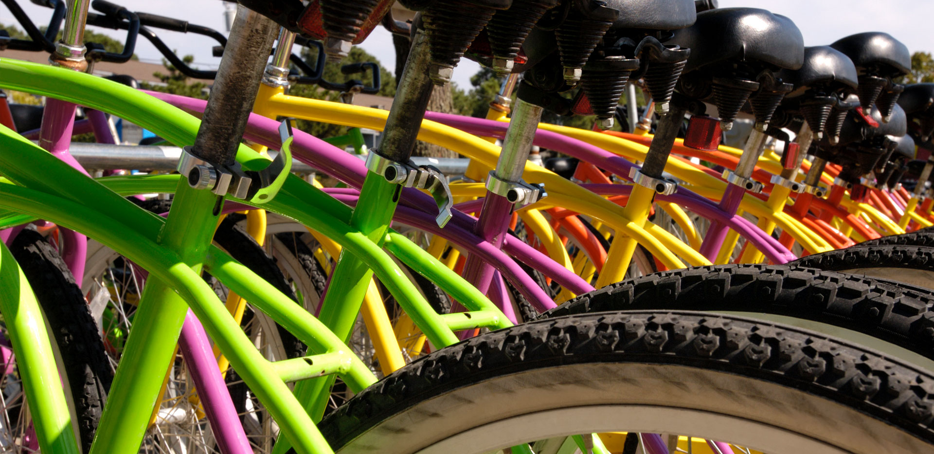 A close up of colorful bicycles lined up side-by-side.