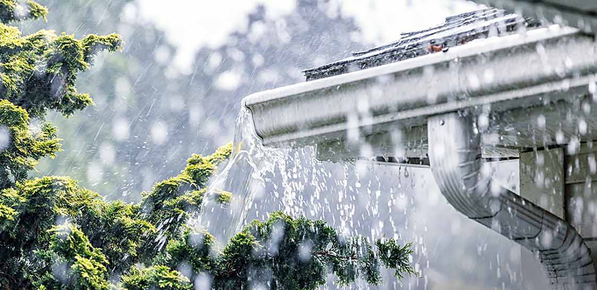 A gutter overflowing with rain.