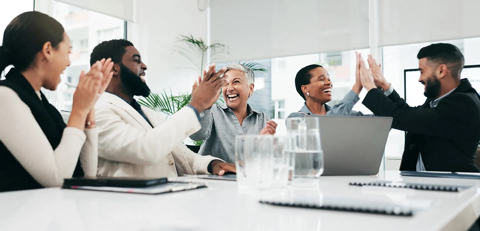 A group of professionals smiling and high-fiving.