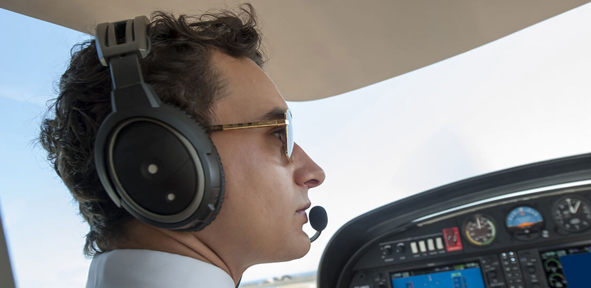 A close up of a pilot wearing a headset.
