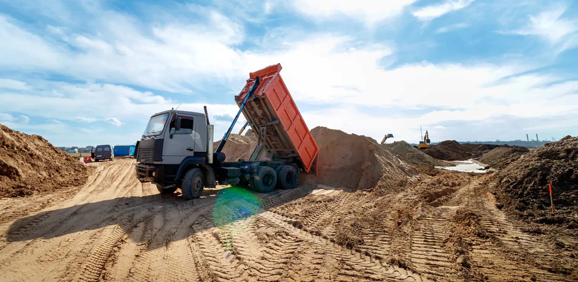 A dump truck unloading a load of sand.