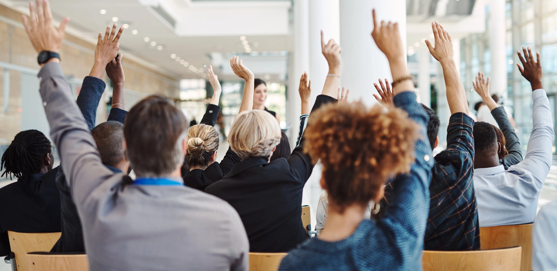 people in business office raising their hands 