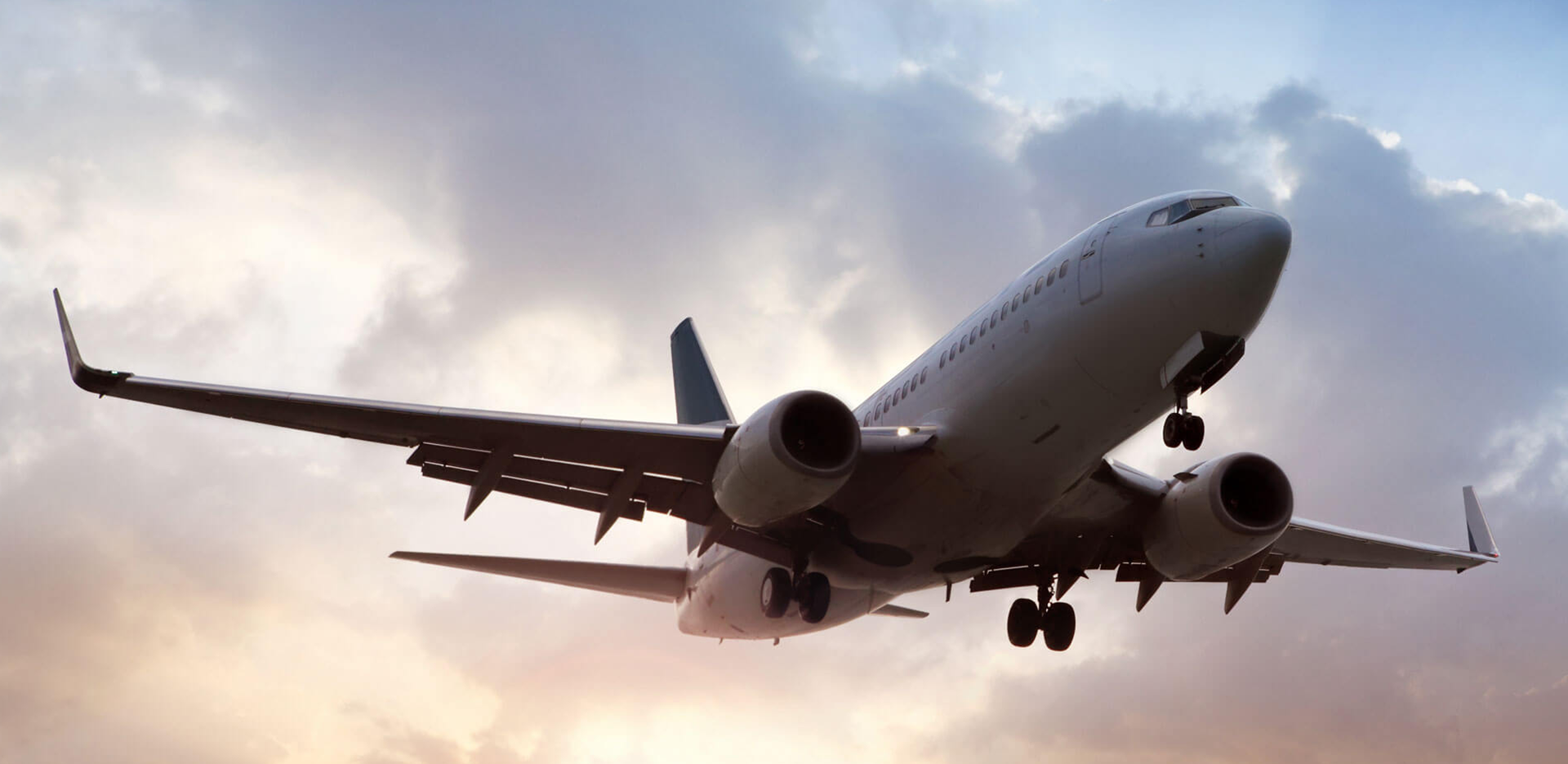 An airplane in flight against a cloudy sky.