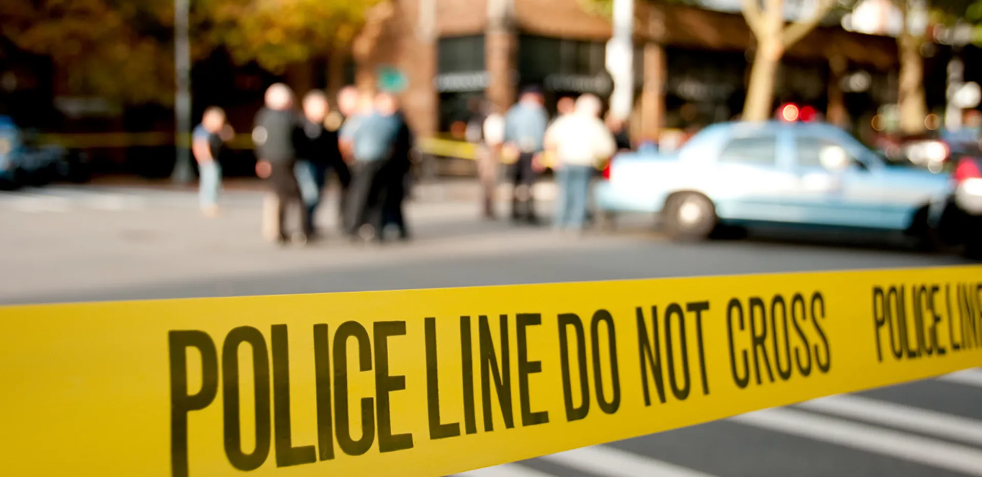 Yellow tape reading 'police line do not cross' with an out-of-focus background.