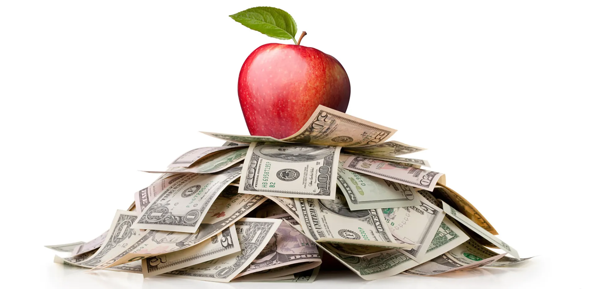 An apple on top of a pile of money.