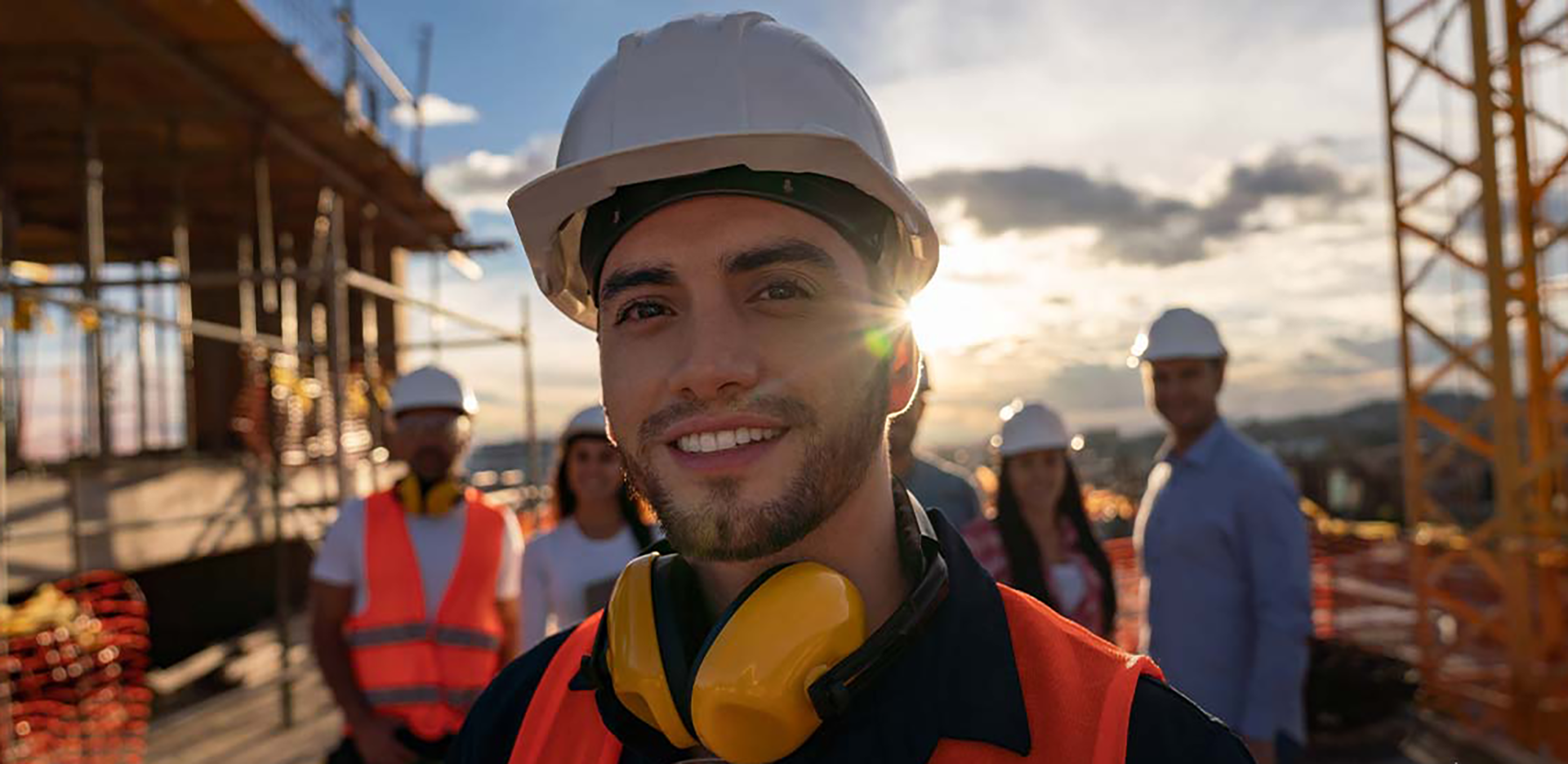 Close-up of a construction worker, with other team members in the background.