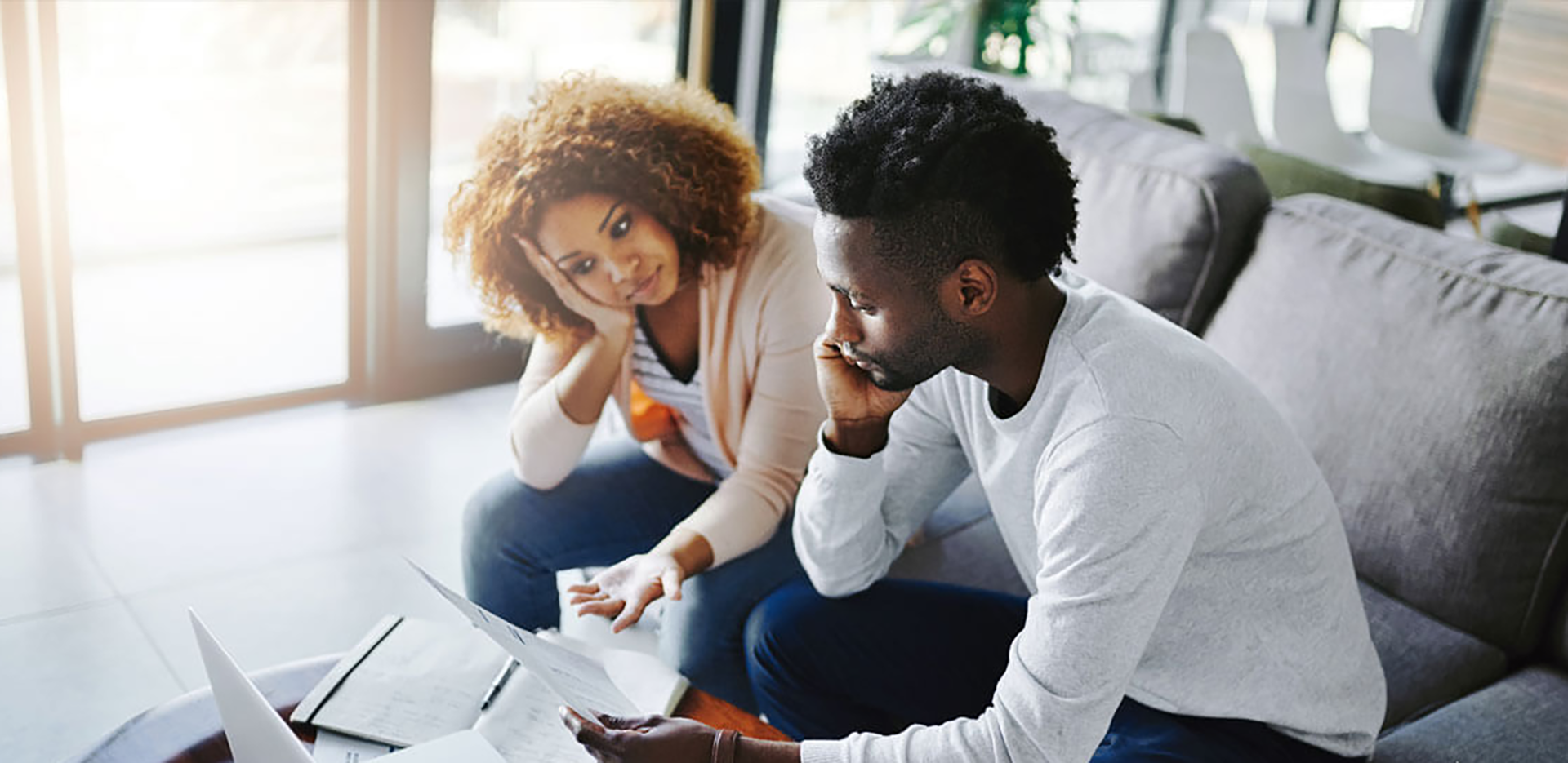 Homeowners reviewing paperwork at their laptop computer.