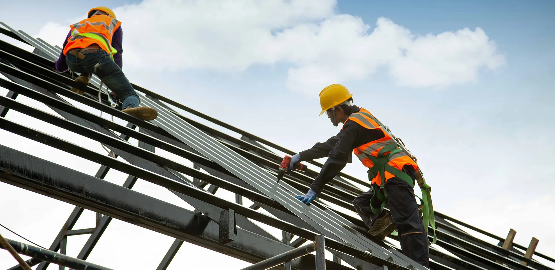 Two construction workers on scaffolding.