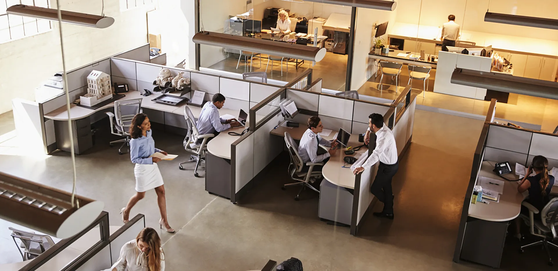 An overhead view of office workers in cubicles.