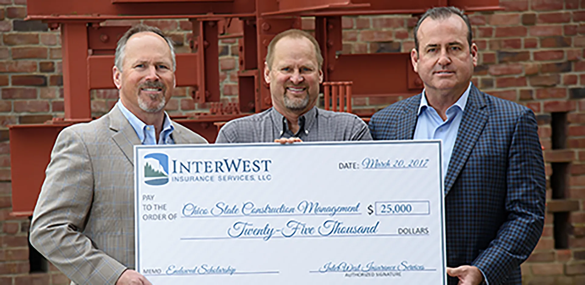 A group of InterWest team members standing with a large check representing a donation to CSU Chico.
