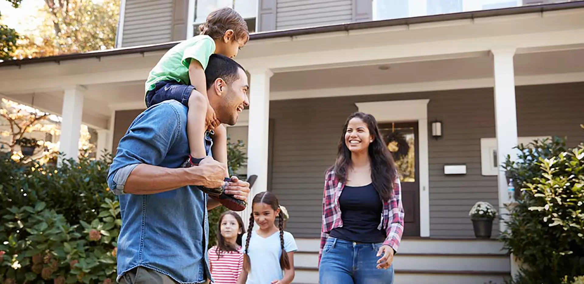 A happy family standing in front of their home.