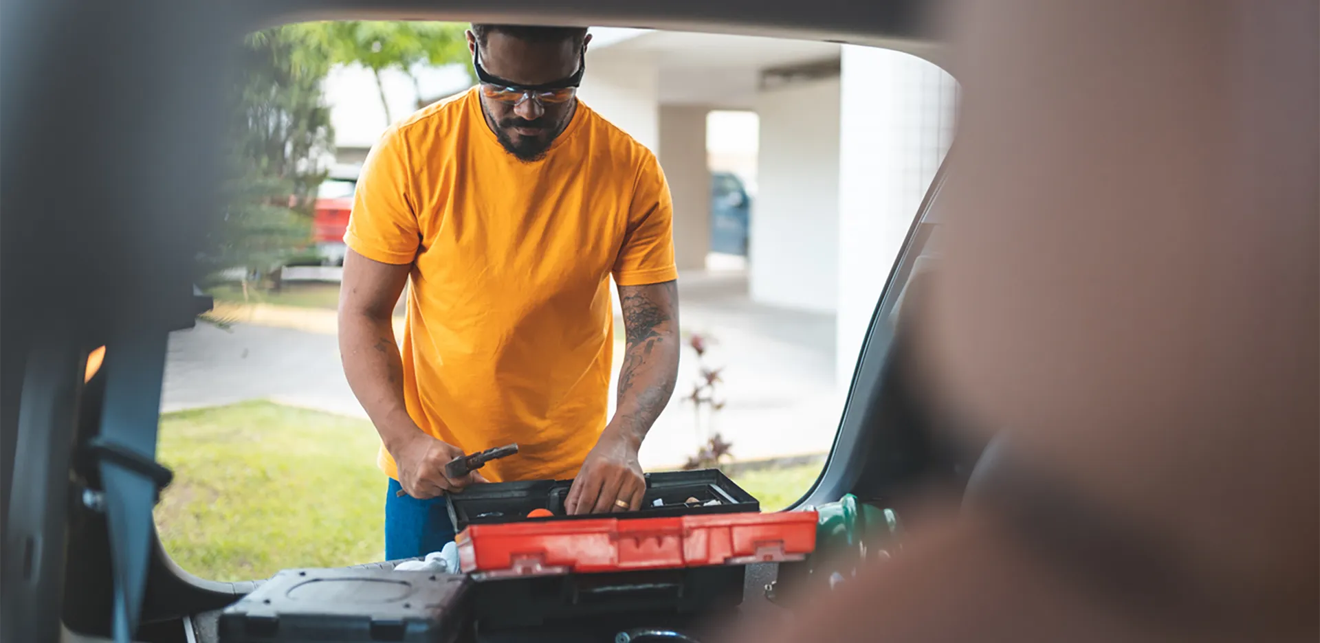 A man looking through an open toolbox.
