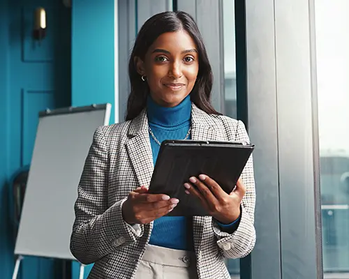 A group of students raising their hands in a classroom.