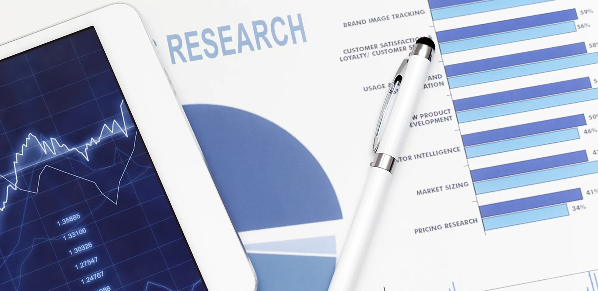 A pen and a tablet lying on top of a paper report titled 'research.'