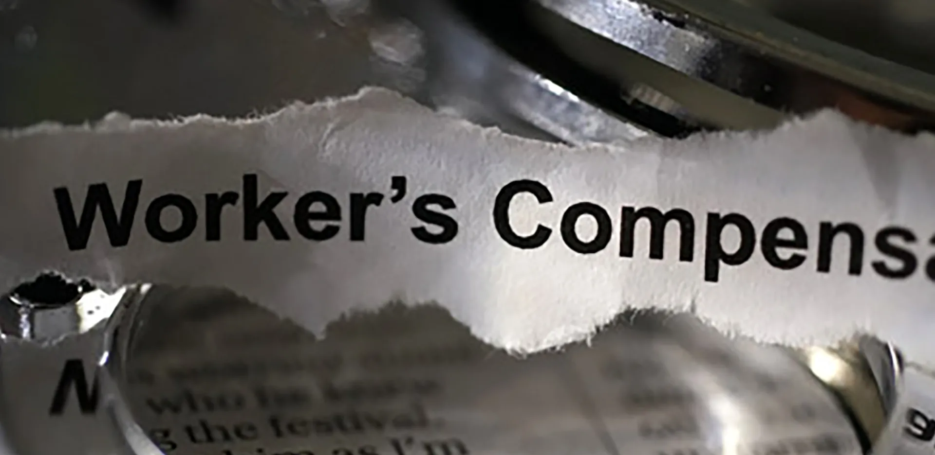 A torn piece of paper reading 'Workers Compensation.'