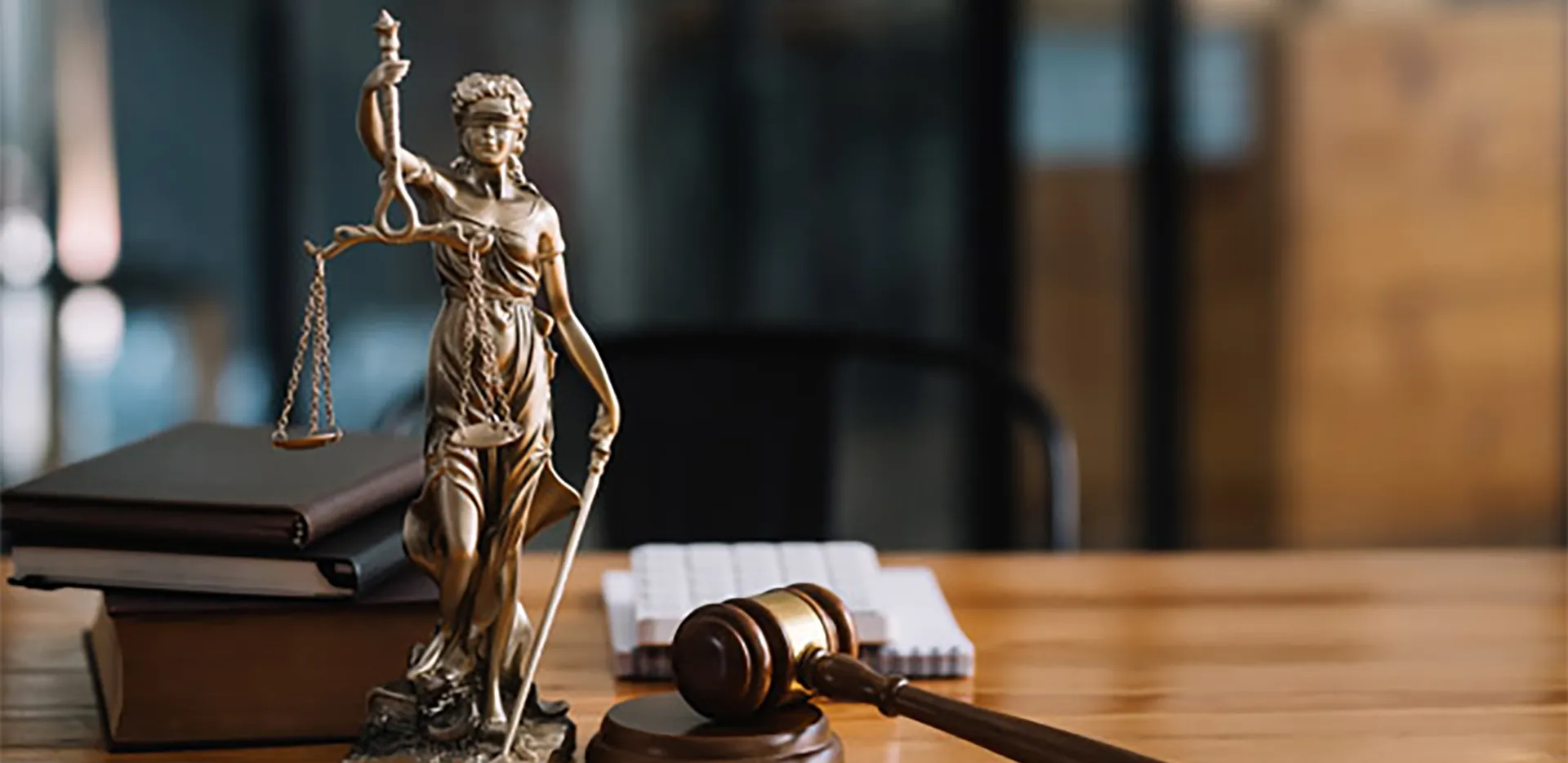 A statue of Lady Justice next to a gavel and sounding block.