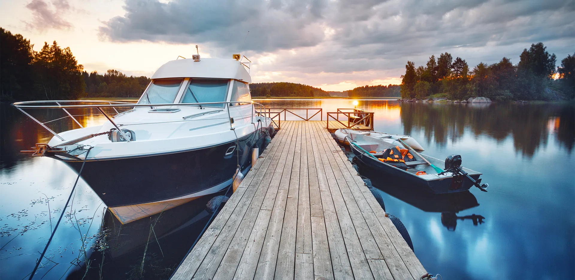 Two boats tied to a wooden dock on a lake.