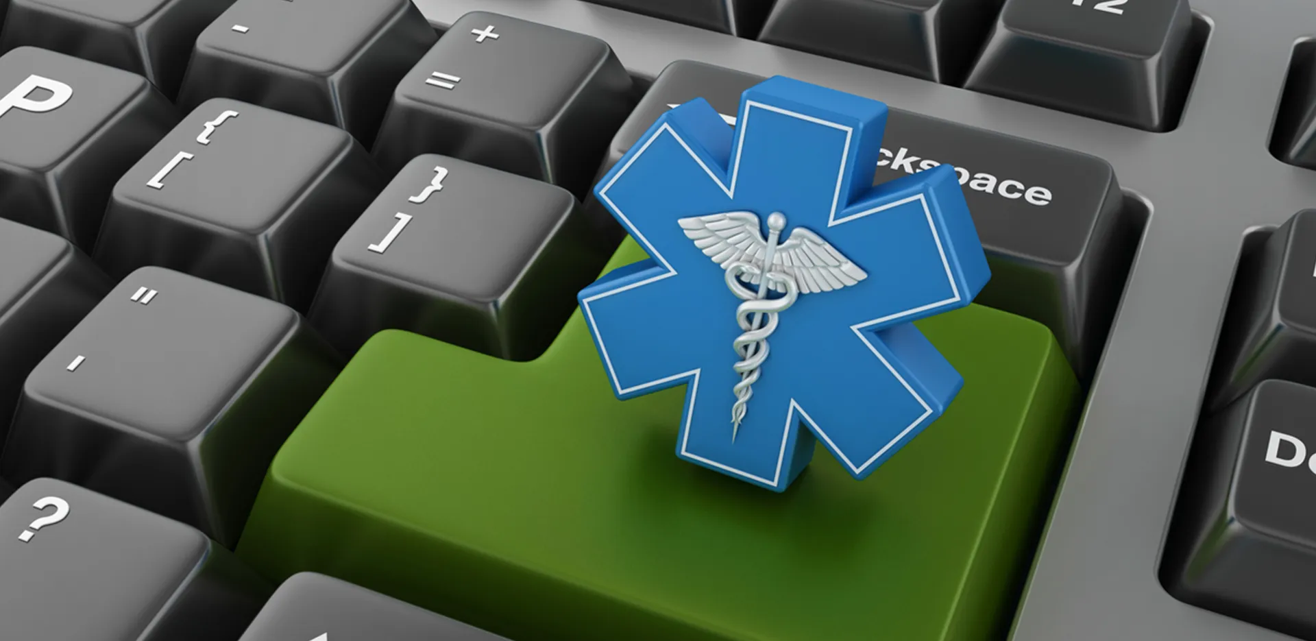 A close up image of a keyboard with a medical caduceus in a blue asterisk shape on the return key.