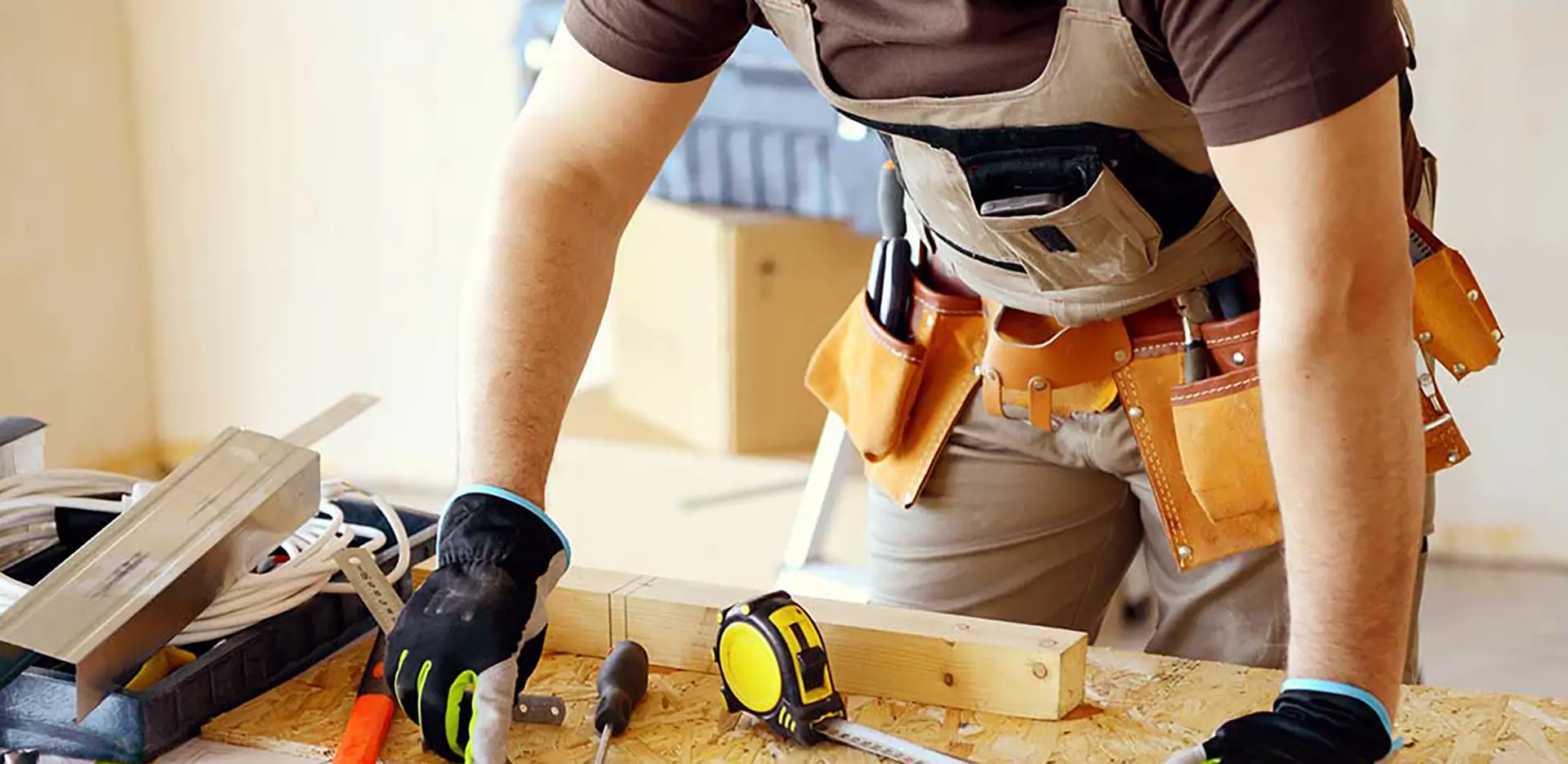 A contractor at a workbench surrounded by tools.