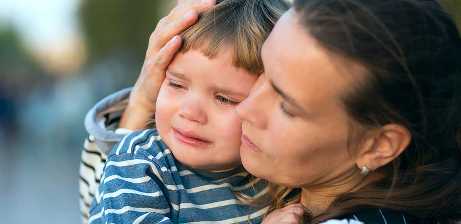A woman holding a crying child.