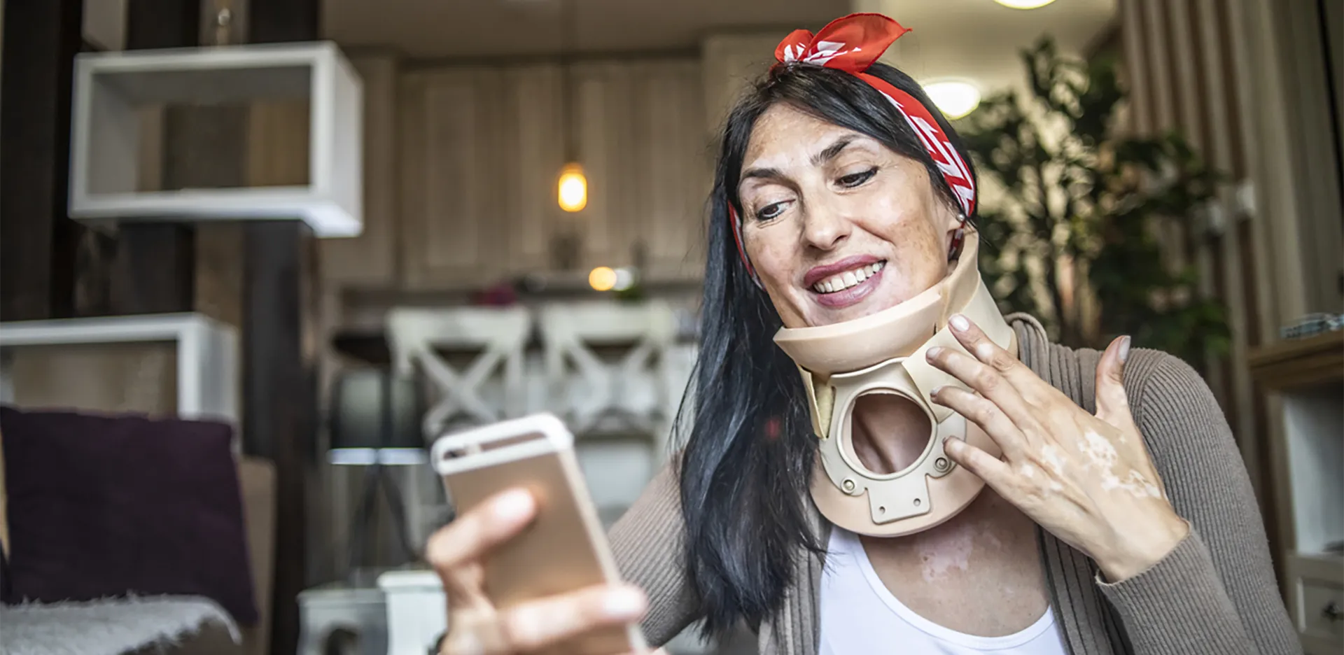 A woman in a neck brace using her cell phone.