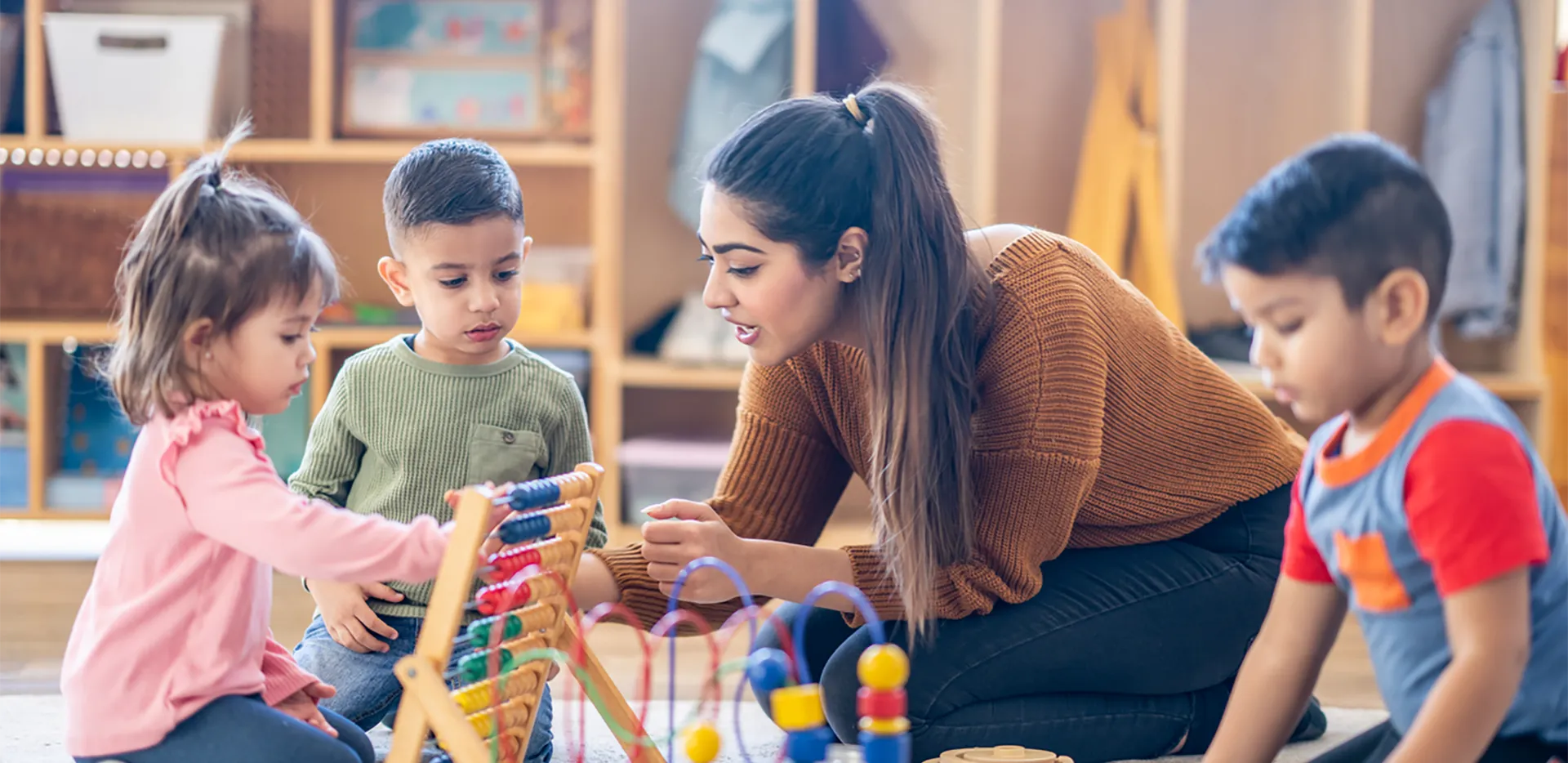 A childcare worker with a group of young children.