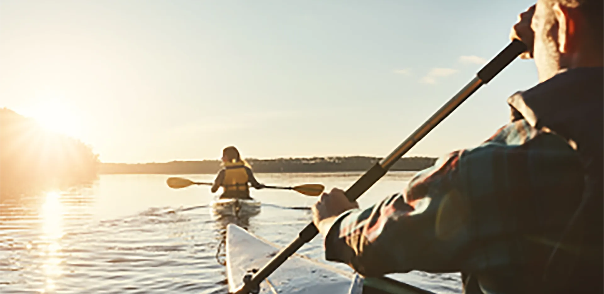 Two people kayaking on a lake.