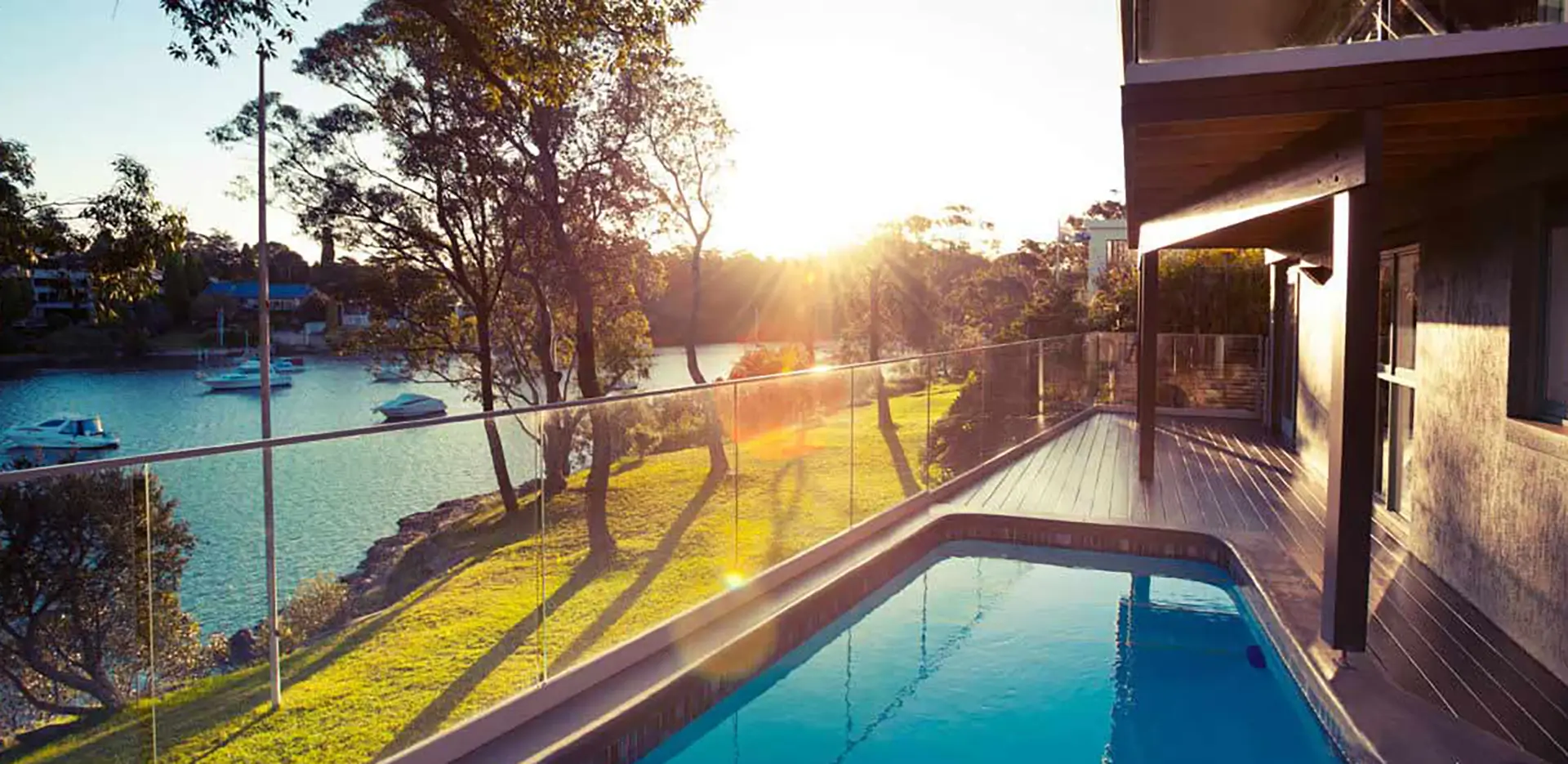 A home's patio and pool next to a green lawn.