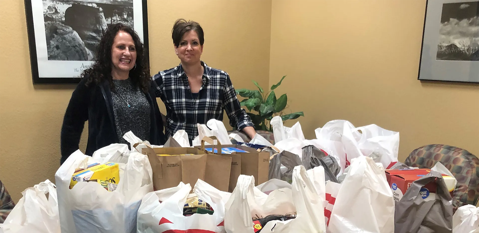 Two team members from the InterWest Hollister Office with holiday donations.