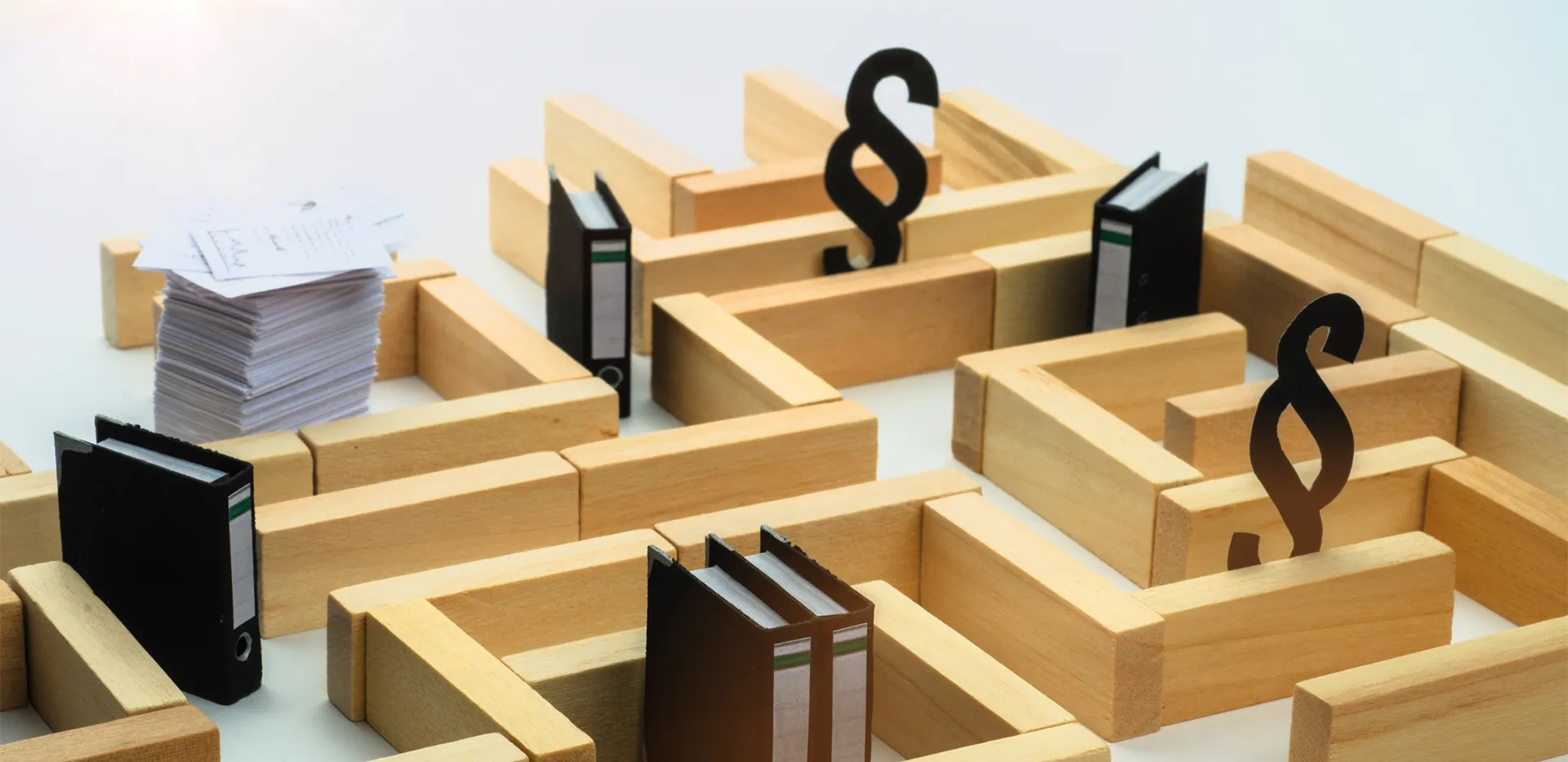 A maze made out of blocks with binders and papers throughout the maze.