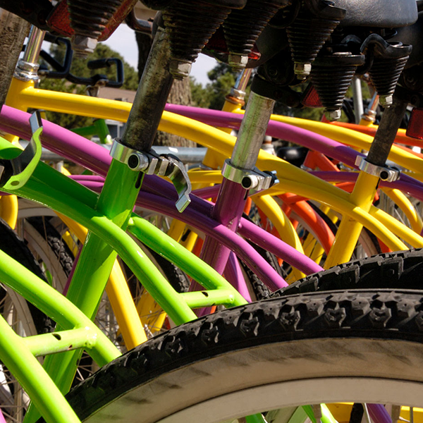 A close up of colorful bicycles lined up side-by-side.