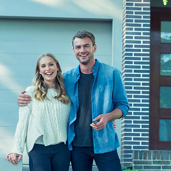 A smiling couple holding the keys to their new home.
