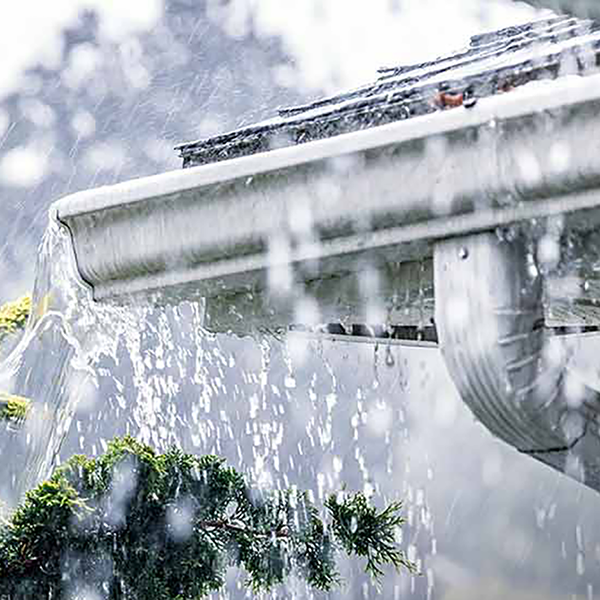 A gutter overflowing with rain.