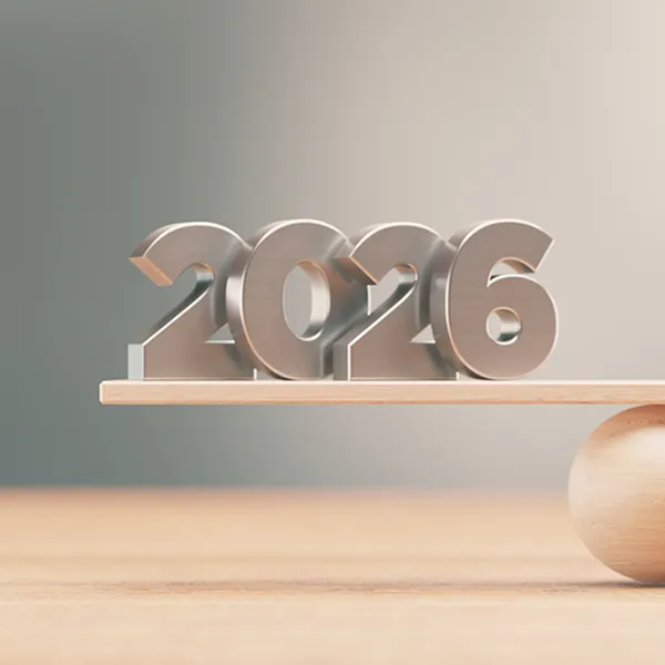 A graphic featuring the numbers '2026' balanced next to a stack of coins.