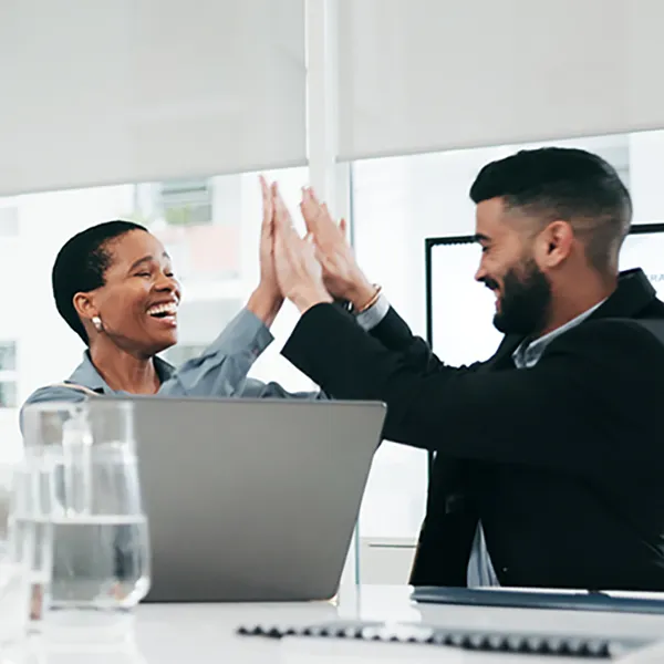 A group of professionals smiling and high-fiving.