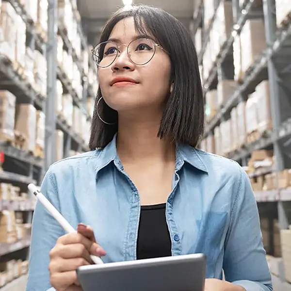 A woman with a tablet and stylus taking notes in a construction store.