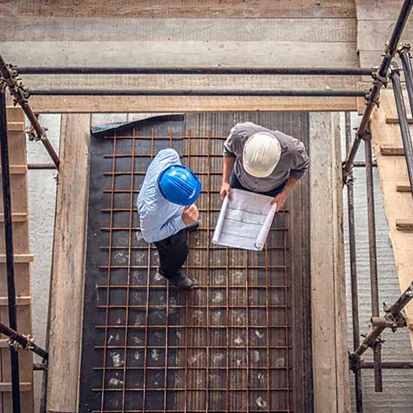 A bird's eye view of four contractors wearing hard hats on a job site.