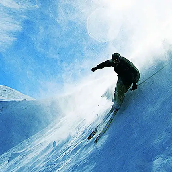 A skier going down a steep mountain.