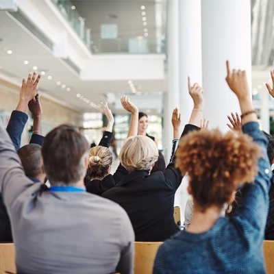 people in business office raising their hands 