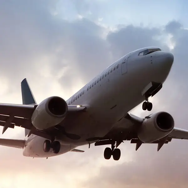 An airplane in flight against a cloudy sky.