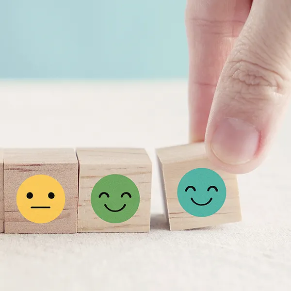 A series of wooden blocks with images of faces portraying different emotions on them.