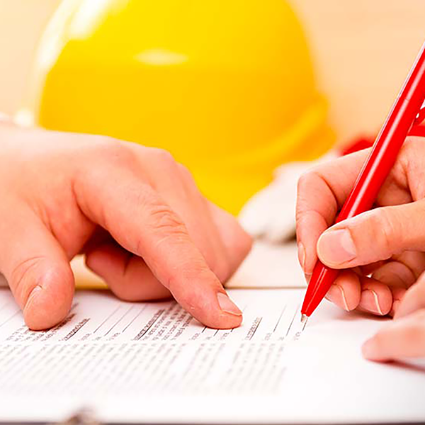 A view of someone's hands filling out a form with red pen.