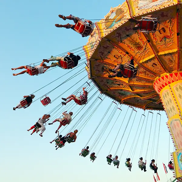 A view looking up at a swing ride at an amusement park.