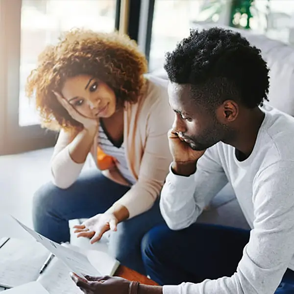 Homeowners reviewing paperwork at their laptop computer.