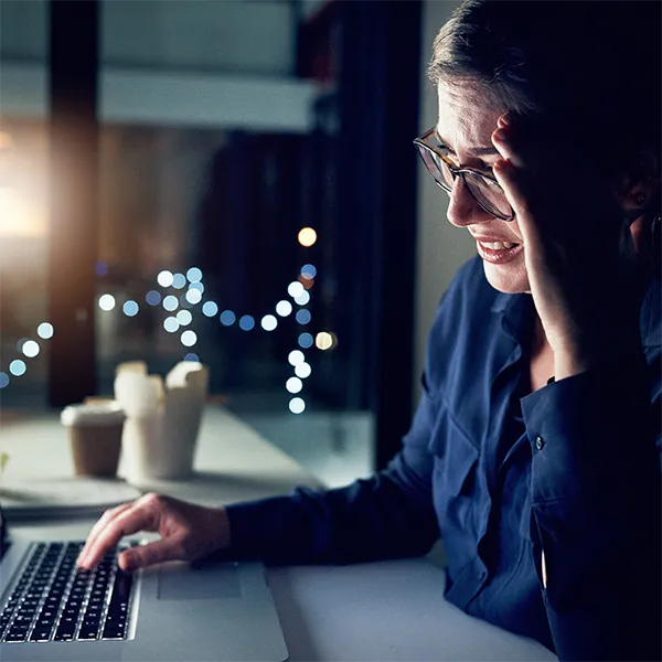 A woman looking with frustration at a computer screen, which reads 'you have been hacked!'