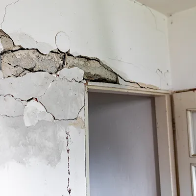 A doorway with a badly cracked wall above it.