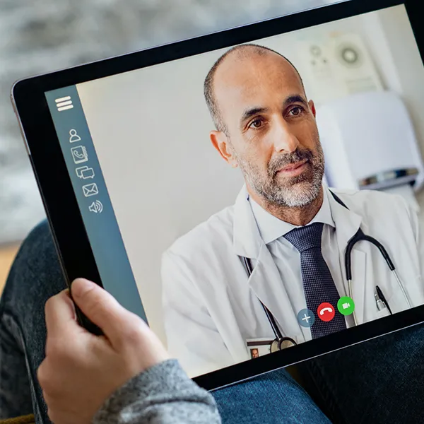 A patient speaking with their doctor via video call on a tablet.