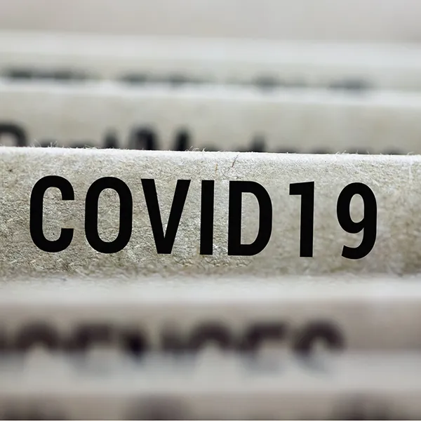 A close up of the labels on filing folders. One reads 'COVID 19.'