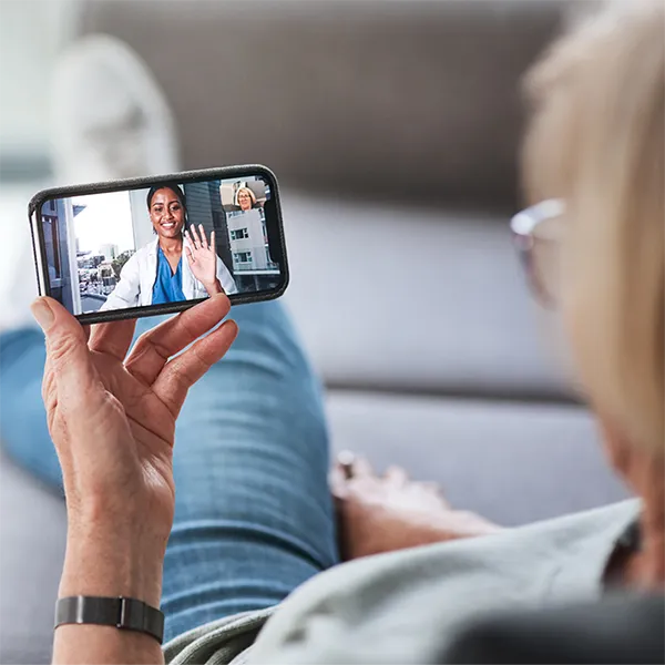 A patient speaking with their doctor via video call on a cell phone.