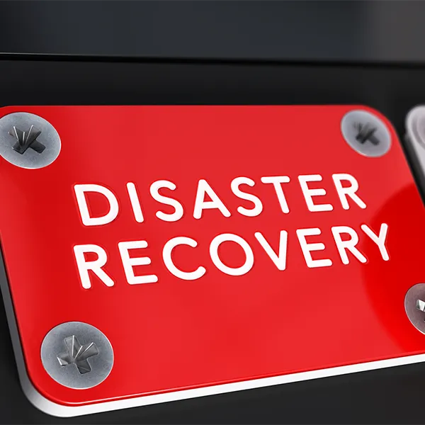 Concept of a sign reading 'Disaster Recovery' next to a large red button labeled 'push.'